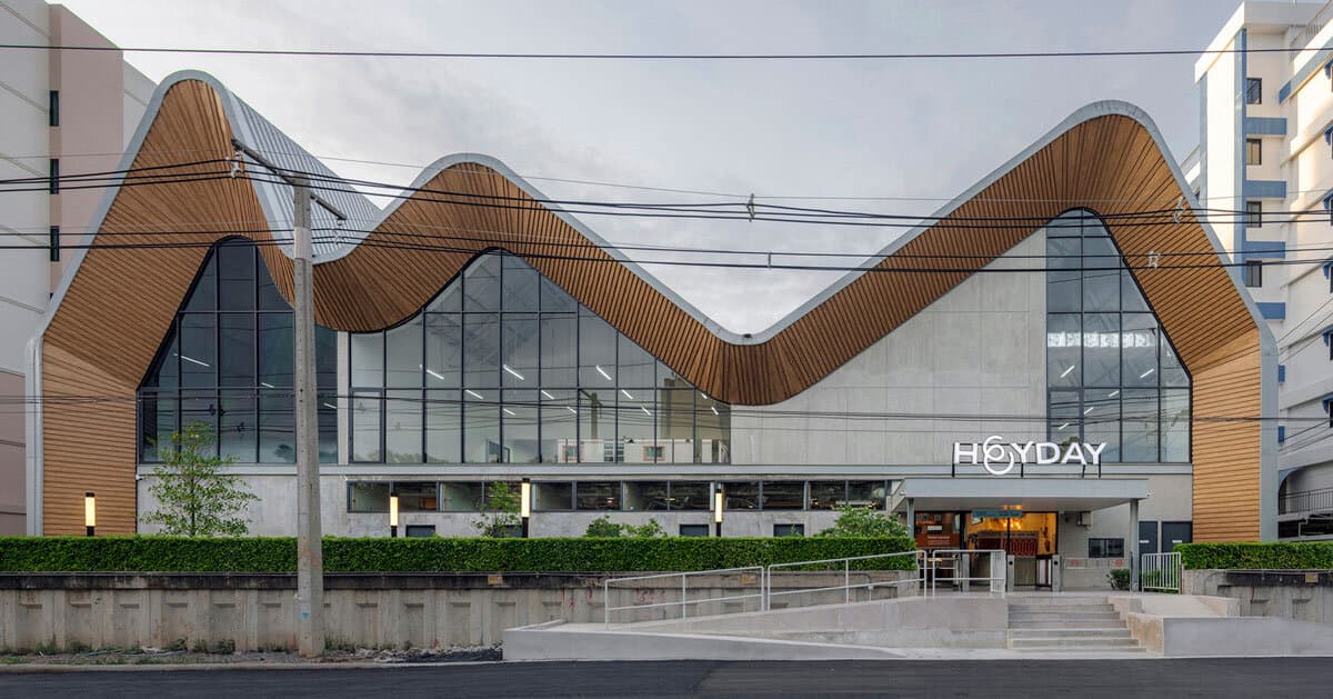 three asymmetrical curved gable roofs top ASWA’s community hub in thailand